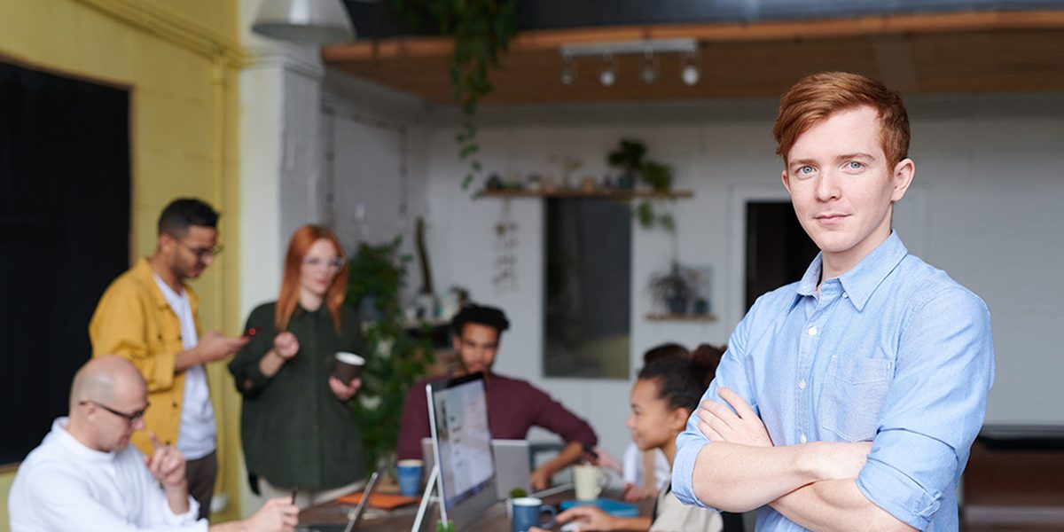 man-standing-beside-people-sitting-beside-table-with-laptops-31843951.jpg